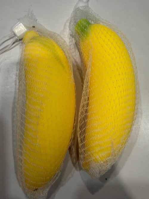 Two yellow banana squishies in mesh packaging
