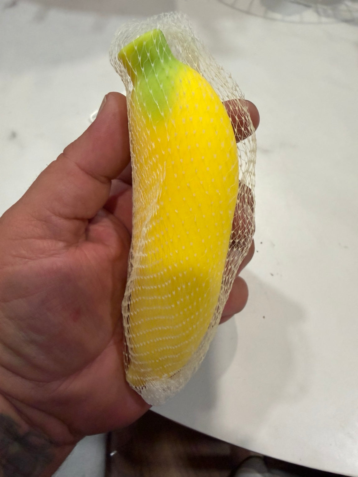 Yellow banana squishy held in hand