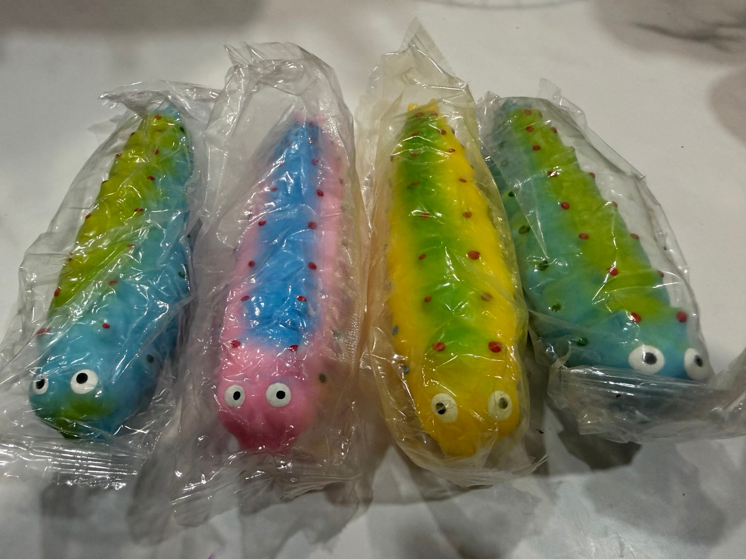 Assorted colorful caterpillar squishy toys in blue, green, pink and yellow