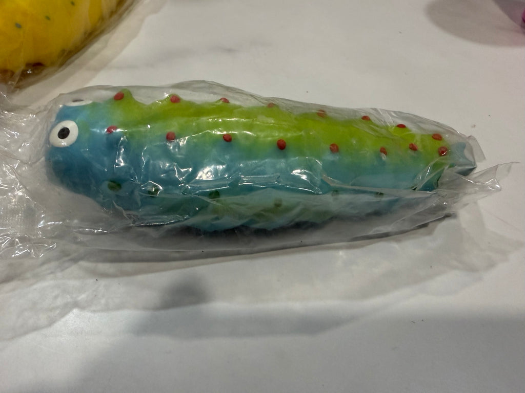 Blue and green caterpillar squishy toy with cartoon eyes and red bumps