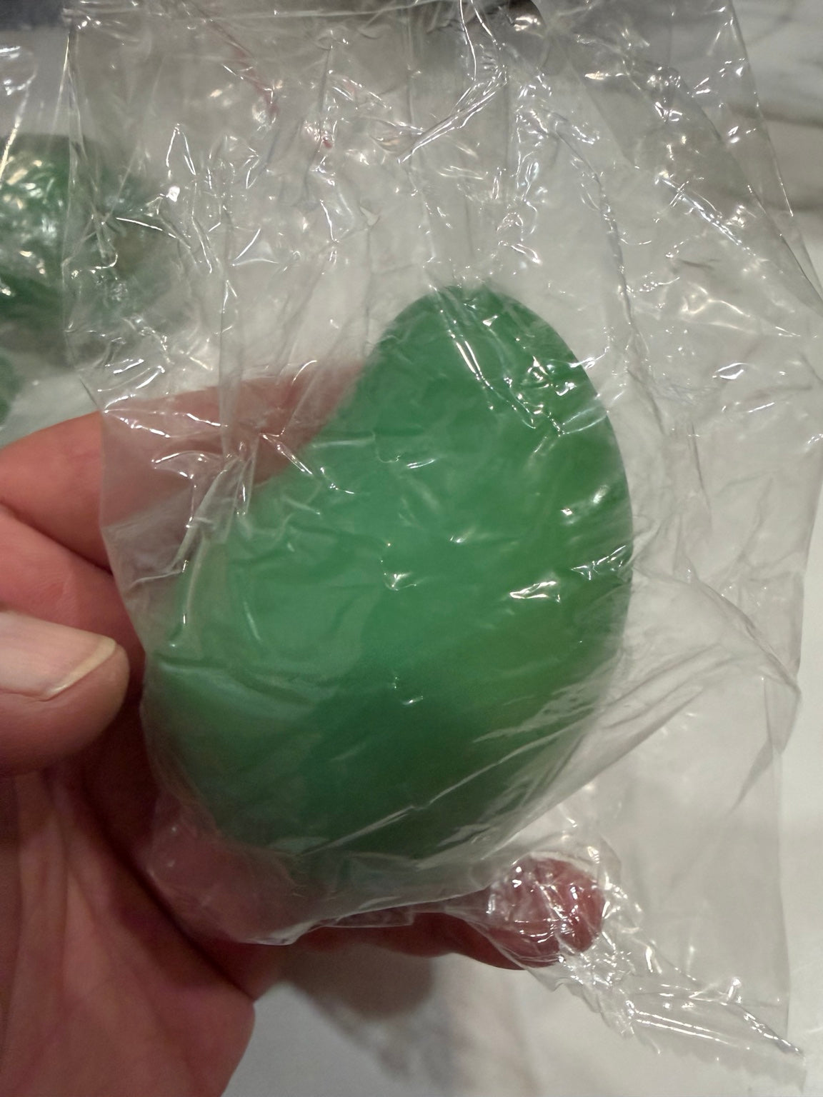 Green mango squishy toy held in hand