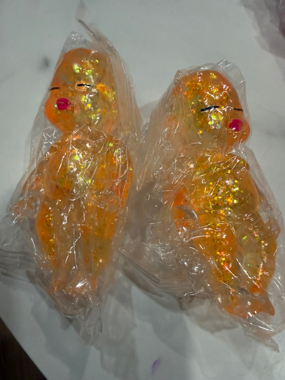 Orange glitter-filled baby doll squishy toy