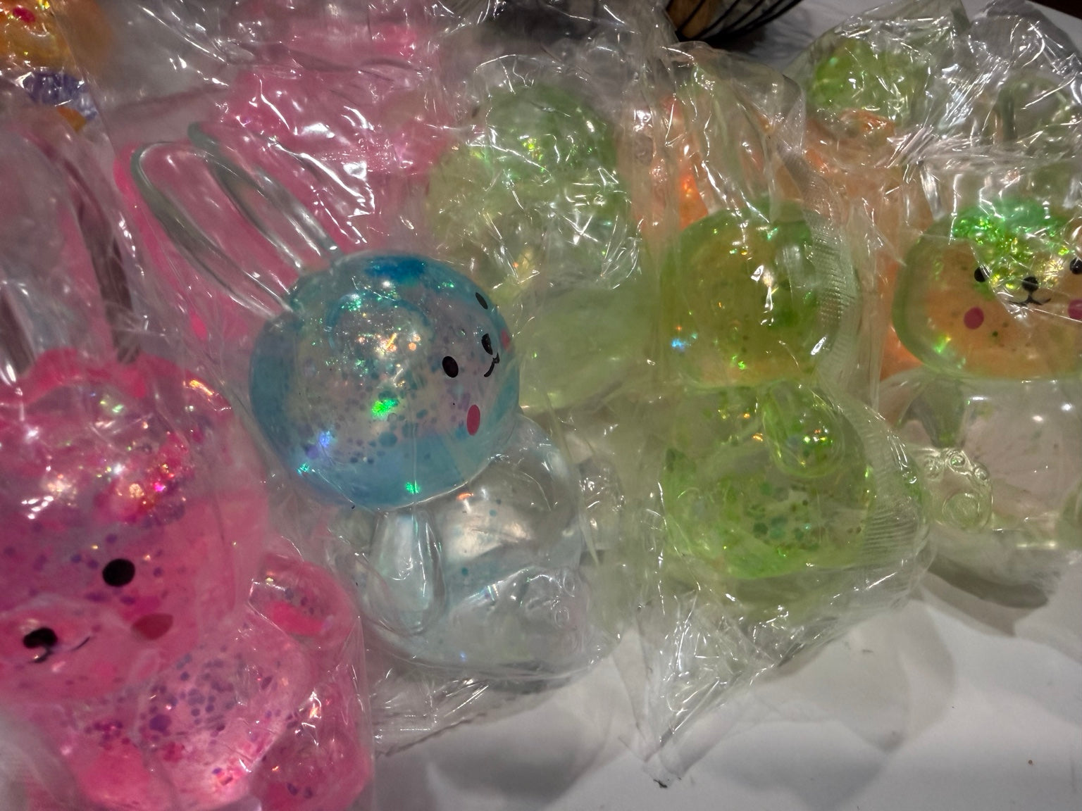 Assorted glitter bunny squishy toys in pink, blue, green and orange