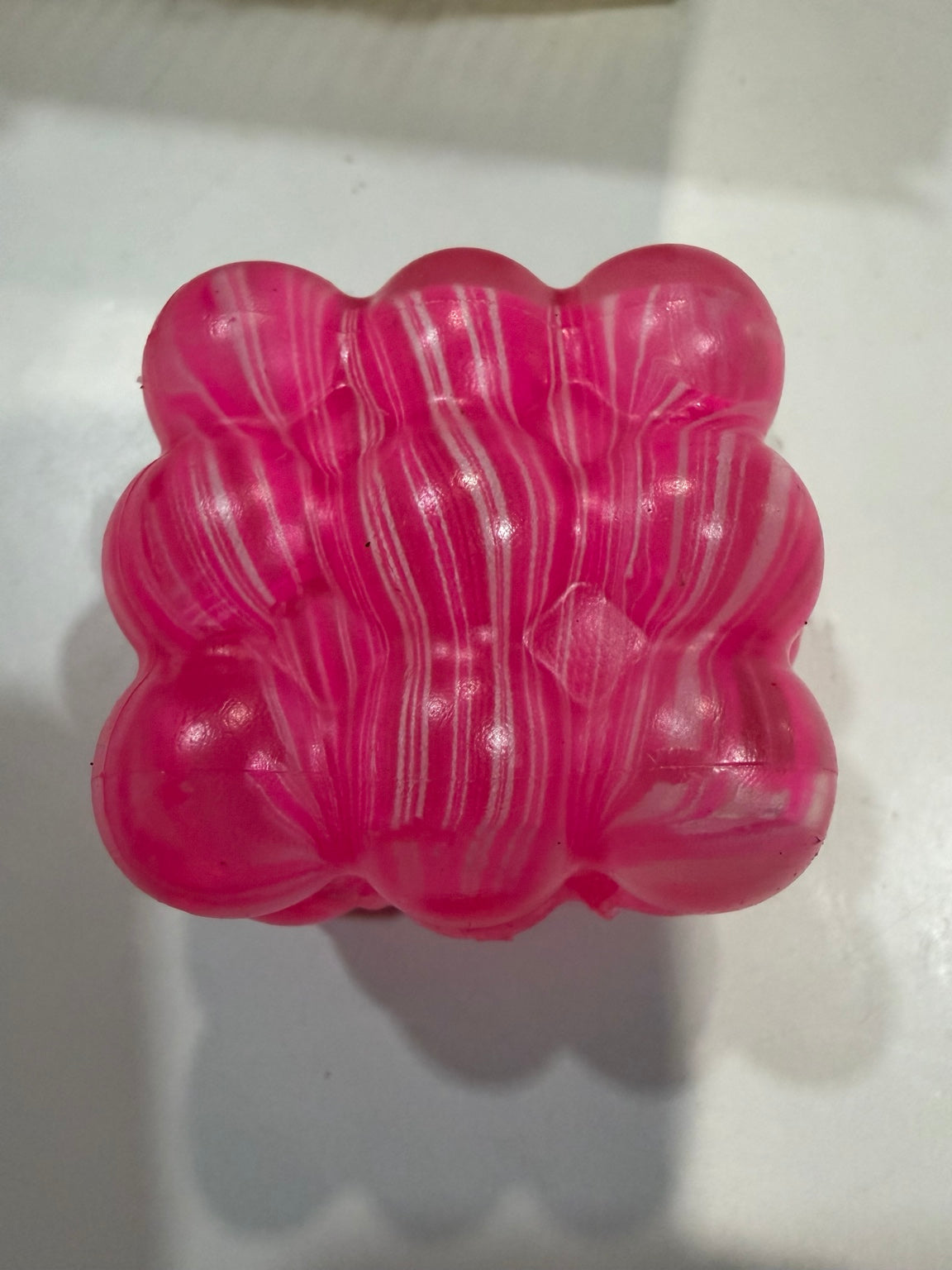 Pink marbled translucent bumpy cube squeeze toy