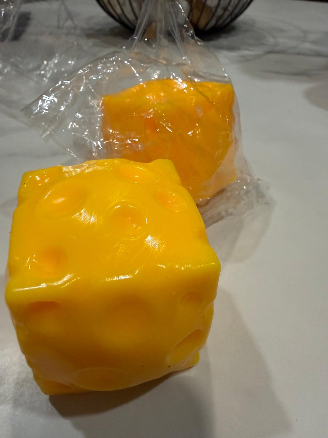 Yellow cheese-shaped squishy toy with Swiss-cheese-style holes