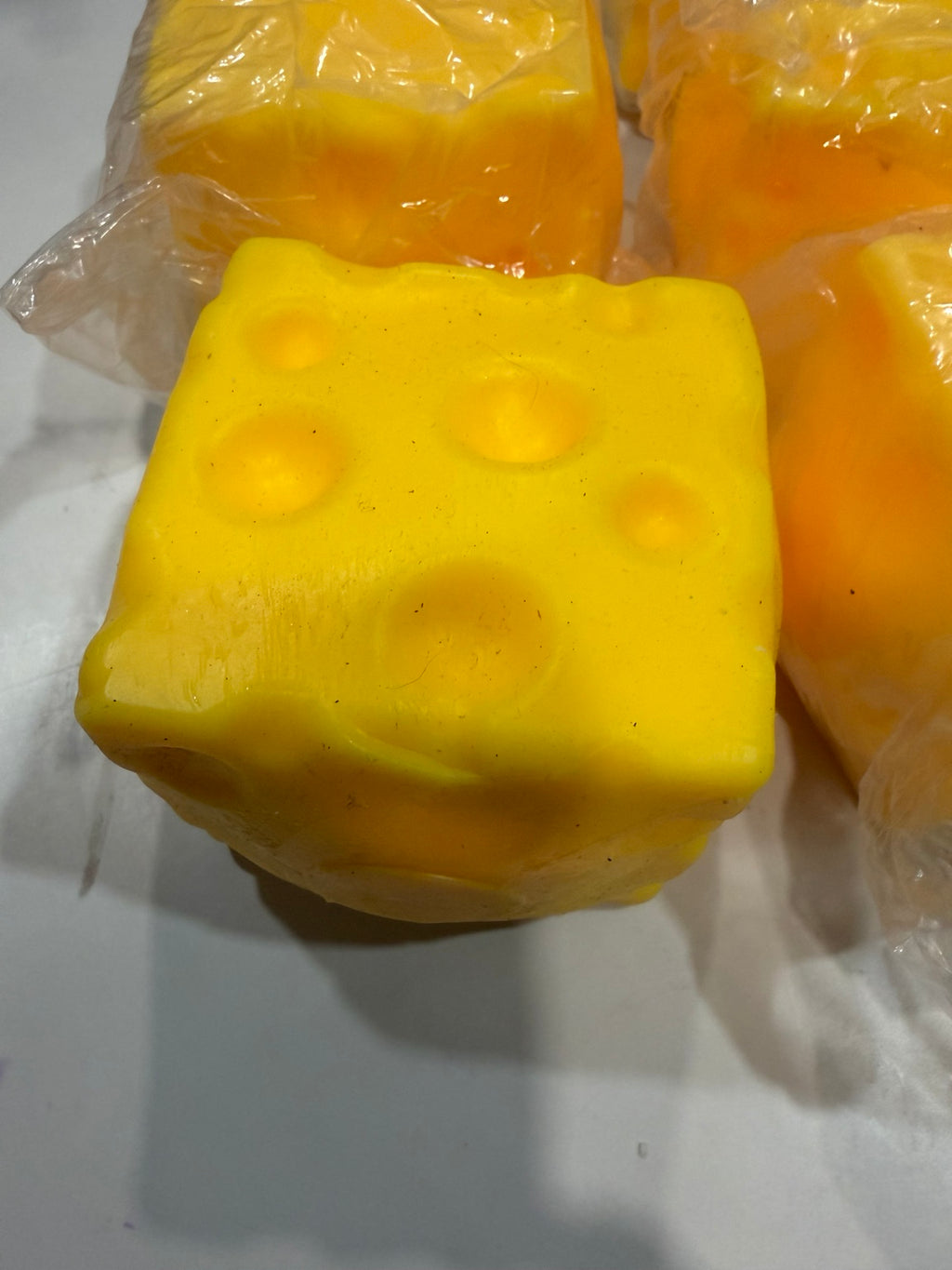 Close-up of medium yellow cheese-shaped squishy toy with holes