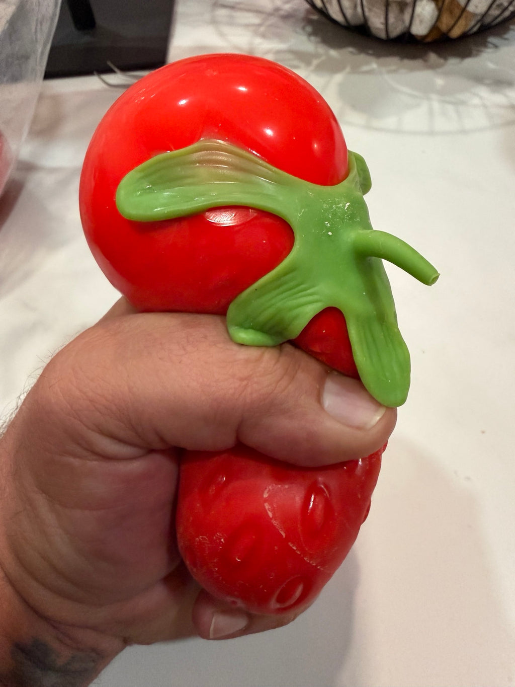 Strawberry squishy being squeezed by hand