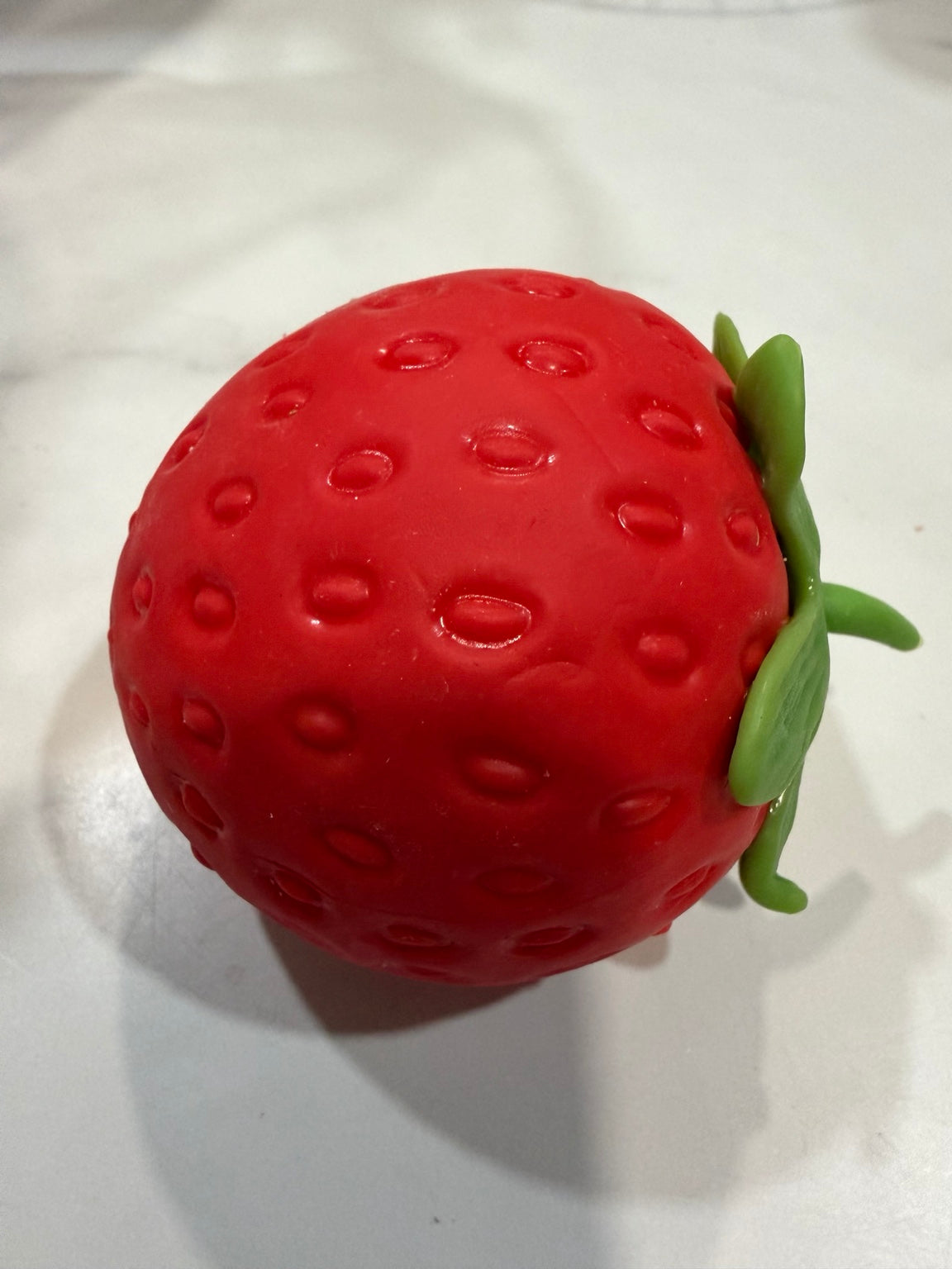 Red strawberry-shaped squishy sensory toy